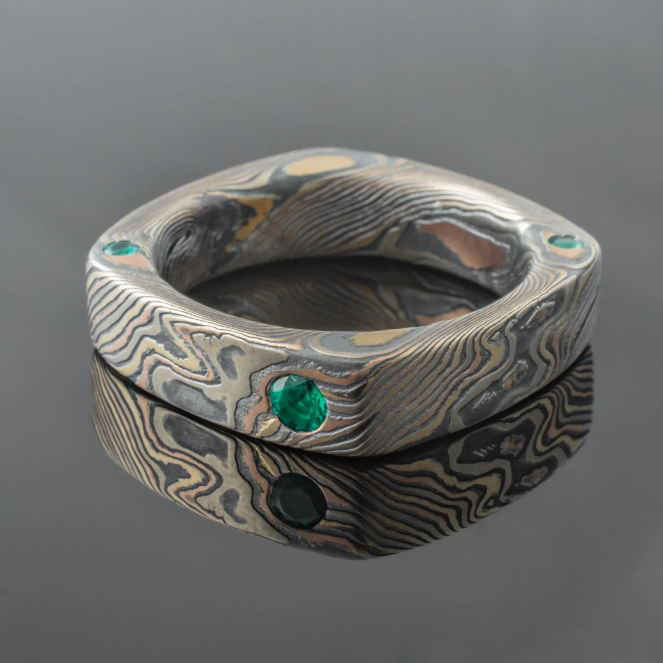 Square Mokume Gane Ring Wedding Band in Twist Pattern and Oxidized Firestorm Palette with Flush Set Emeralds